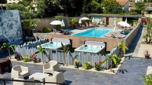 a swimming pool with chairs and people sitting around it at Logis Hôtel Restaurant Bellevue in Saint-Martin-dʼArdèche
