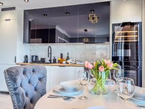 a kitchen with a table with a vase of flowers on it at URBAN APARTMENTS GLOBAL SKYLINE, 15th Floor No 23, Free Garage, Self Check-in, No Deposit in Katowice