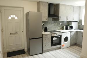 a kitchen with a refrigerator and a washing machine at Cosy Getaway near beach in Southend-on-Sea +9 photos