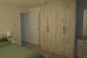 a bedroom with a large wooden cabinet and a bed at Cosy Getaway near beach in Southend-on-Sea