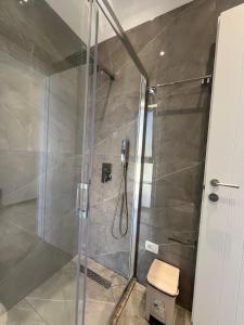 a bathroom with a shower with a glass door at Niks apartments in Vlorë