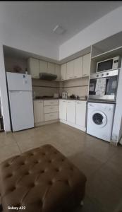 a kitchen with white appliances and a washer and dryer at Faluma Quilmes in Quilmes