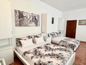 a bedroom with two beds and a painting on the wall at Pansion Ivana studios in Baška Voda