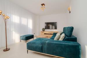 a living room with a blue couch and a table at The Sun in Ninski Stanovi