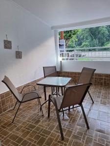Un patio con una mesa y sillas y una ventana. en Achilleas Apartments, en Paralía Skotínis 85 fotos más