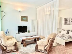 a living room with two chairs and a television at Pansion Ivana studios in Baška Voda