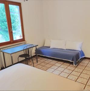 a room with a bed and a table and a window at Peaceful Lakefront in Marone