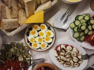 a table topped with plates of eggs and bread at Pensiunea Buon Gusto Sibiu-motorcyle friendly,city center in Sibiu