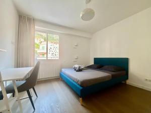 a bedroom with a blue bed and a table at Sea-view Sunrise condo close beaches and Monaco in Cap d'Ail