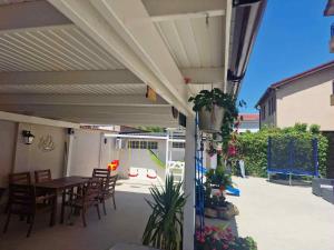 a patio with a table and chairs under awning at Virginia Mamaia-Nord in Mamaia Sat/Năvodari