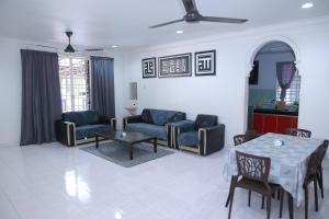 a living room with a couch and chairs and a table at Green Dream Homestay 4 Bilik & Ruang Tamu Aircond 3 Bilik Air Wifi Kota Bharu in Kota Bharu
