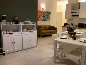 a kitchen and living room with a table and a couch at B&B Ulivi in Leporano Marina