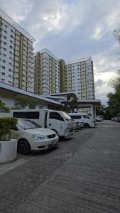 a parking lot with cars parked next to tall buildings at roberts loft 12mT3 mesaverte near SM and Ayala in Pontud
