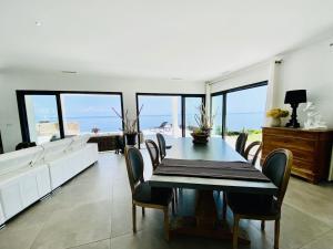 a dining room with a table and chairs and the ocean at Villa prestige au bord de l'eau- Pietracorbara in Pietracorbara