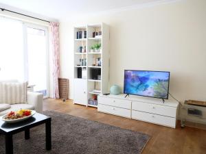 a living room with a flat screen tv on a white cabinet at Ostertresker 78, DHH in Tinnum