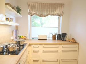 a kitchen with a counter top with a window at Ostertresker 78, DHH in Tinnum
