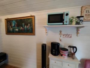 a wall with a microwave and a painting on it at Apartment Lena in Strömbergshyttan