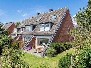 a house with a large extension to the side of it at Ostertresker 78, DHH in Tinnum