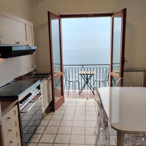 a kitchen with a balcony with a view of the ocean at Peaceful Lakefront in Marone