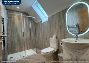 a bathroom with a toilet and a sink and a mirror at Pine Trees Leisure Park in Skegness +44 photos