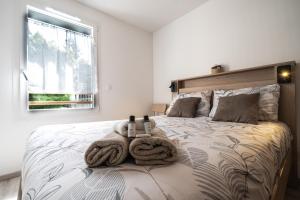a bedroom with a bed with towels on it at Appartement Neuf au pied Prorel in Briançon