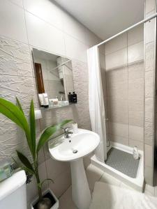 Un baño blanco con lavabo y ducha. en Luxury Living SKG 1, en Tesalónica 4 fotos más