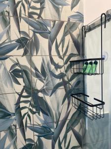 un bagno con un murale di foglie sul muro di Il Rosmarino a Napoli
