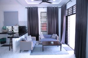 a living room with a blue chair and a table at Green Dream Homestay 3 Kota Bharu 3 Aircond Room With Wifi & Netflix in Kota Bharu