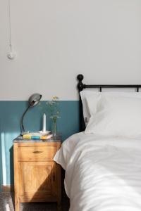 a bedroom with a bed and a lamp on a night stand at Fritto Misto Comune Stays in Fabriano