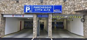 ein Mann, der mit einem Schild durch ein Parkhaus geht in der Unterkunft Namastè Apartment Città Alta with hills view in Bergamo + 13 Fotos