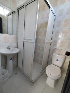 a bathroom with a shower and a toilet and a sink at Hotel Madeleine Inn Sede Sur in Barranquilla