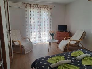 a bedroom with a bed and two chairs and a tv at Apartments vila Vanda in Poreč