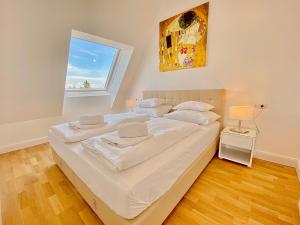 uma grande cama branca em um quarto com janela em Steiner Residences Mödling em Mödling