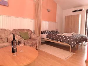 a living room with a couch and a table with wine glasses at Apartments vila Vanda in Poreč