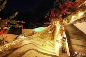 a pathway leading to a swimming pool at night at InSense Mountainview Resort in Siquijor