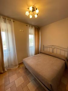 a bedroom with a bed and two windows at Casa Vacanze Salus in Cascia
