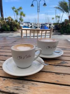 two cups of coffee sitting on a wooden table at Apartamento en Moraira Centro con Piscina in Moraira