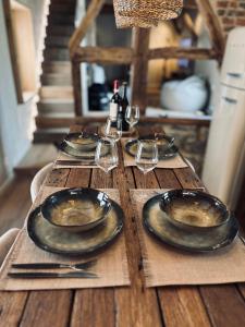 a wooden table with plates and wine glasses on it at Au ptit Gaston in Durbuy +28 photos
