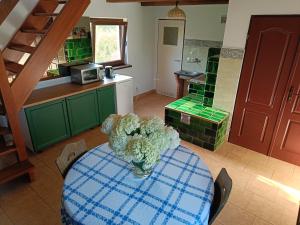 a kitchen with a table with a vase of flowers on it at Domek Pszczelarza in Krasnopol