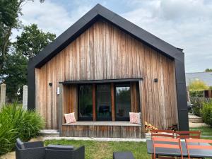 a small wooden house with a black roof at La Ptite Maison du Minihic in Le Minihic-sur-Rance