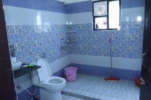 ein Badezimmer mit einem WC und einer Uhr an der Wand in der Unterkunft Rooptara Valley Luxury Cottage Majkhali Himalaya in Rānīkhet + 52 Fotos