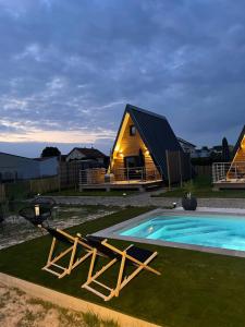 a cabin with a swimming pool and a house at Lady Tipi 3 avec bain nordique et piscine in Saint-Utin