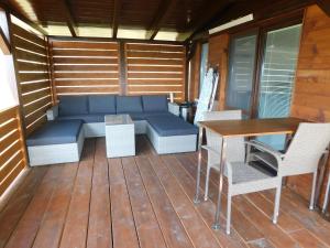 un patio con sofá azul, mesa y sillas en Vodný Horský Park Poruba, en Poruba 17 fotos más