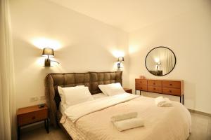 a bedroom with a large bed and a mirror at אירופה בוטיק כנרת - דירת 4 חדרי שינה עם בריכה ונוף לכנרת in Tiberias +43 photos
