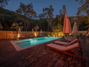 a swimming pool with chairs and umbrellas next to it at Trsteno Beach Apartments in Budva