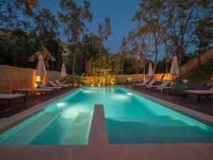 a swimming pool with lounge chairs and umbrellas at Trsteno Beach Apartments in Budva