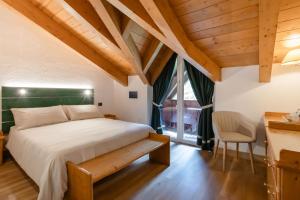 a bedroom with a large bed and a window at B&B Garni Villa Campitello in Campitello di Fassa +29 photos