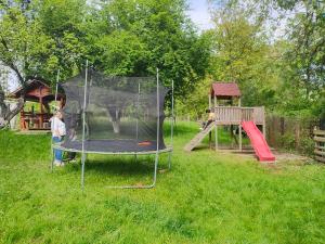 a child playing on a trampoline in a yard at Casa de la Moară in Tureac