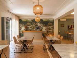 a restaurant with tables and chairs and a painting on the wall at Casa Orfea in Algajola
