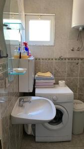 a bathroom with a washing machine and a sink at Apartmani Dević Šušanj in Bar +16 photos
